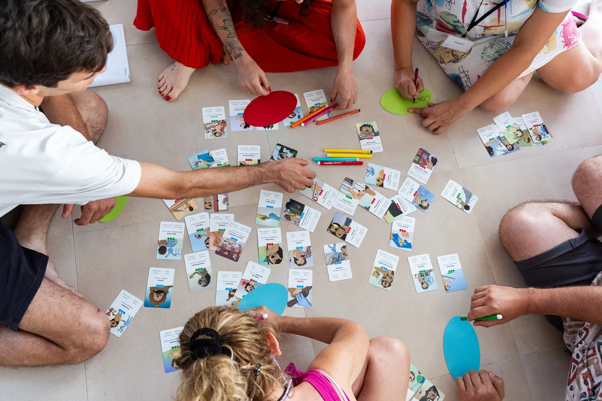 Participantes de una formación de ZINQUO ordenando en el suelo las cartas de El Valor de los Valores